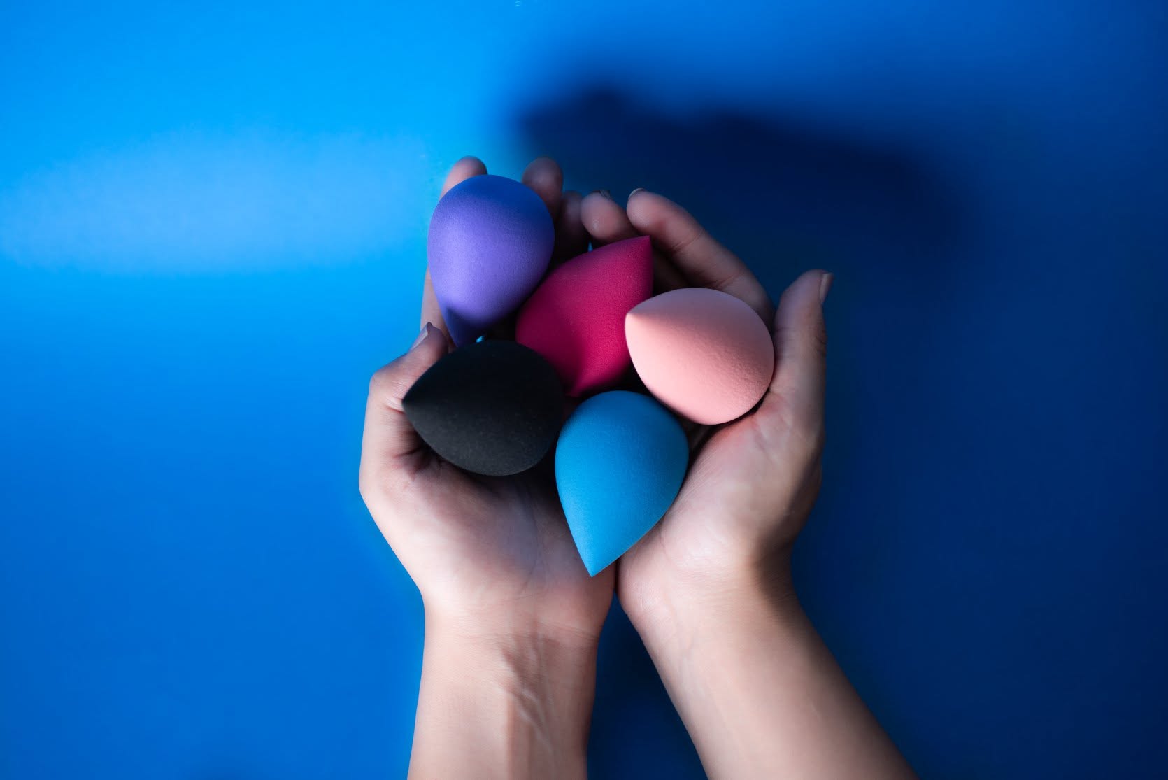 HYGEA BEAUTY multicolour makeup sponges held in hands
